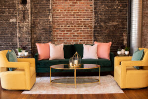 green velvet sofa with yellow chairs